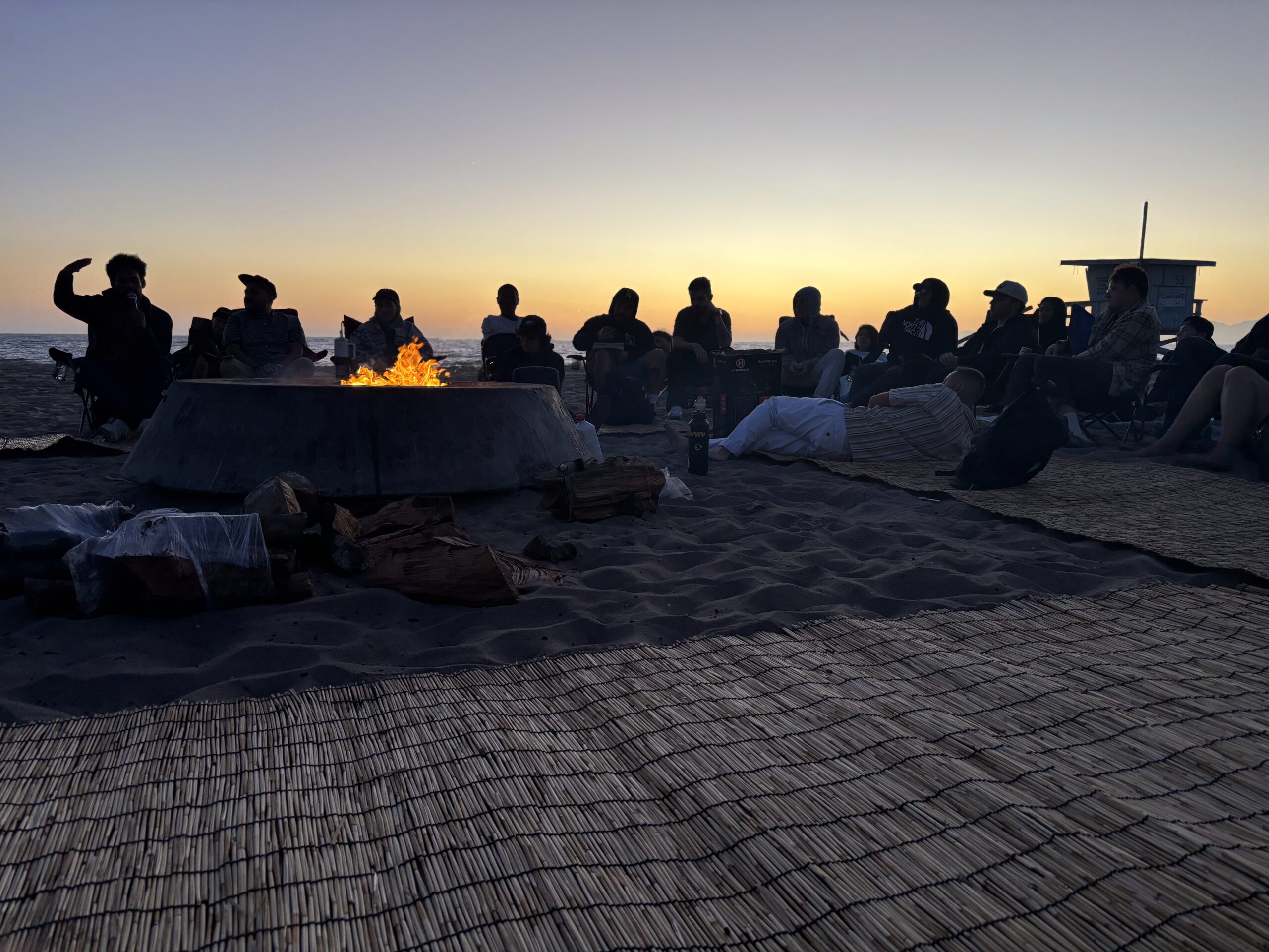 Living Now Sober Living for Men residents sitting at the beach during a Thrive Treatment sponsored event.